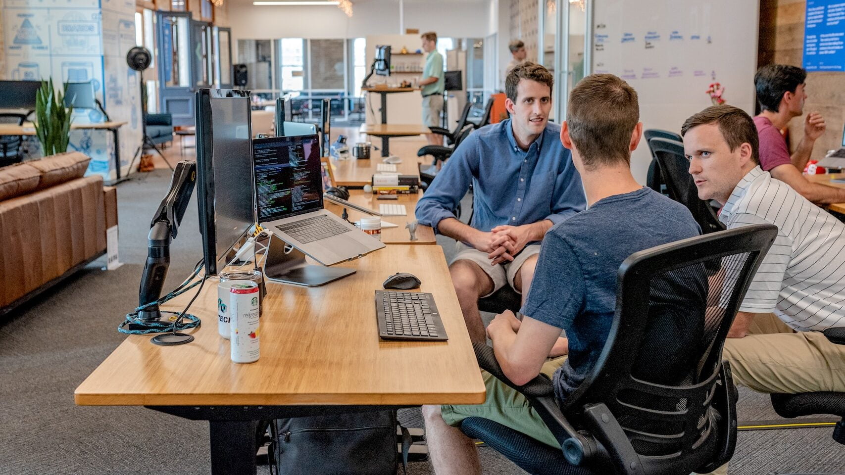 three men sitting on chair beside tables doing the Best Digital Nomad Jobs